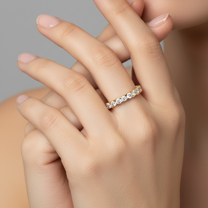Female model wearing yellow gold half eternity diamond band ring with square prong settings