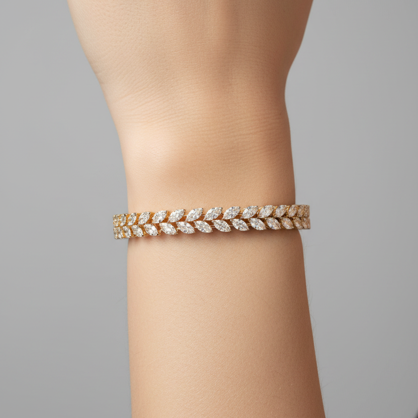 Female model wearing yellow gold marquise diamond leaf wheat sheaf tennis bangle bracelet