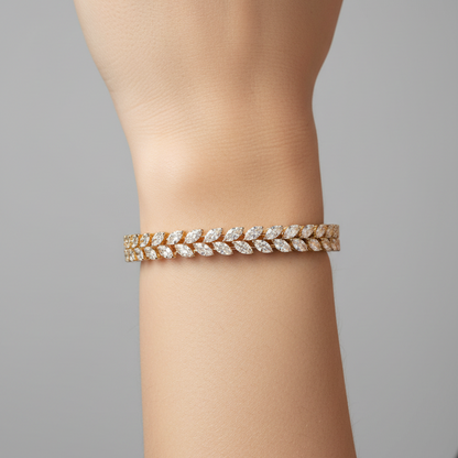Female model wearing yellow gold marquise diamond leaf wheat sheaf tennis bangle bracelet