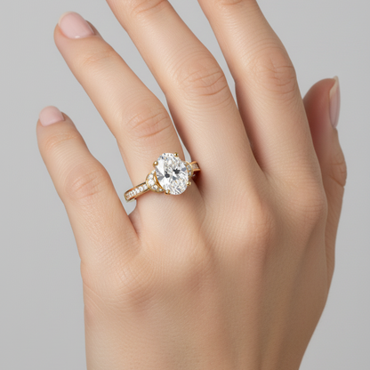 Female model wearing yellow gold oval-cut diamond engagement ring with double-row pavé band and crescent gallery accents
