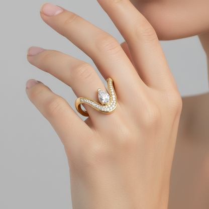 Female model's hand wearing a small bold yellow gold sculptural crown V-shaped lotus ring with two thick wide smooth polished arms curling outward at the tips set with graduating round brilliant pavé diamonds along the inner face and a prominent upward-pointing pear-cut diamond at the center V with a glittering crescent of pavé diamonds cradling it from below