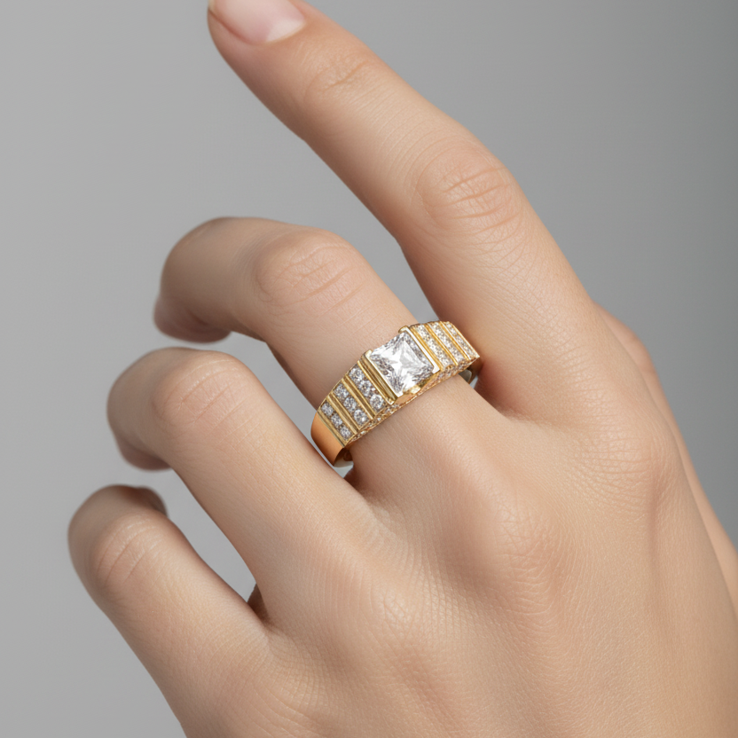 Female model's hand wearing a small yellow gold Art Deco-style princess-cut diamond ring with the center diamond set flush in a square yellow gold frame flanked on both sides by bold stepped architectural parallel raised yellow gold ridges with tiny round brilliant micro-pavé diamonds sparkling in the grooves between the ridges on a smooth tapered yellow gold band