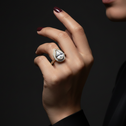 Hand wearing a diamond ring on a dark background