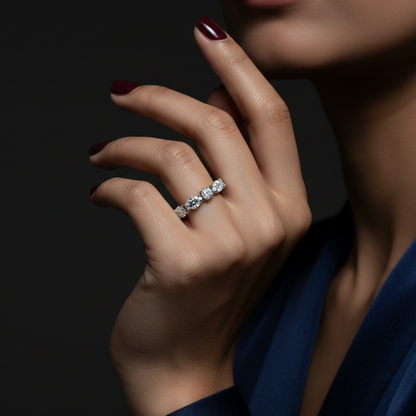 Close-up of a hand wearing a diamond ring on a dark background