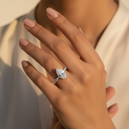 Generated fresh lifestyle variation - Indian female model wearing the white gold marquise-cut diamond solitaire ring with large round brilliant diamond pavé shank, direct overhead top-down angle warm golden hour light on ivory background with delicate blush styling
