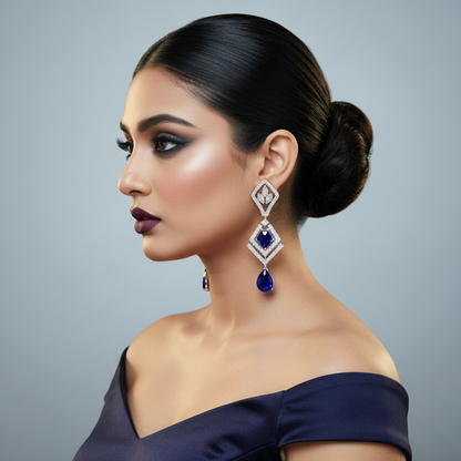 Generated fresh variation - Indian female model wearing the white gold Art Deco sapphire and diamond geometric kite drop earrings in very small size, three-quarter side angle cool silver backlit lighting on pale grey background with deep royal blue bridal styling