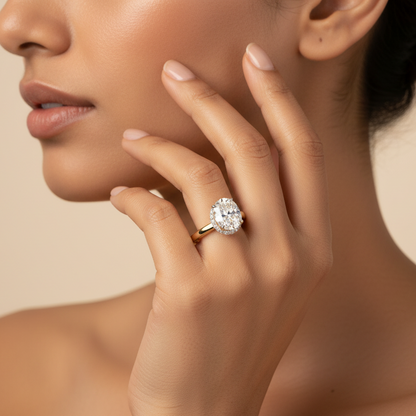 Generated fresh variation - Indian female model wearing the yellow gold east-west oval brilliant solitaire engagement ring with hidden micro-pavé halo under-gallery, warm golden hour side profile shot on champagne background