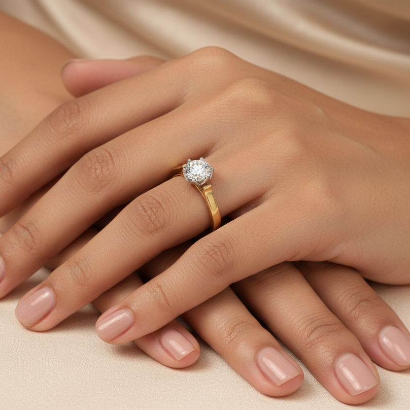 Generated image of a beautiful Indian female model wearing the two-tone yellow gold and white gold round brilliant diamond six-claw solitaire engagement ring with large round brilliant diamond blazing with extraordinary icy fire in white gold six-claw setting on a smooth wide plain yellow gold shank with beautiful architectural bypass-style shoulder connection creating a stunning two-tone contrast