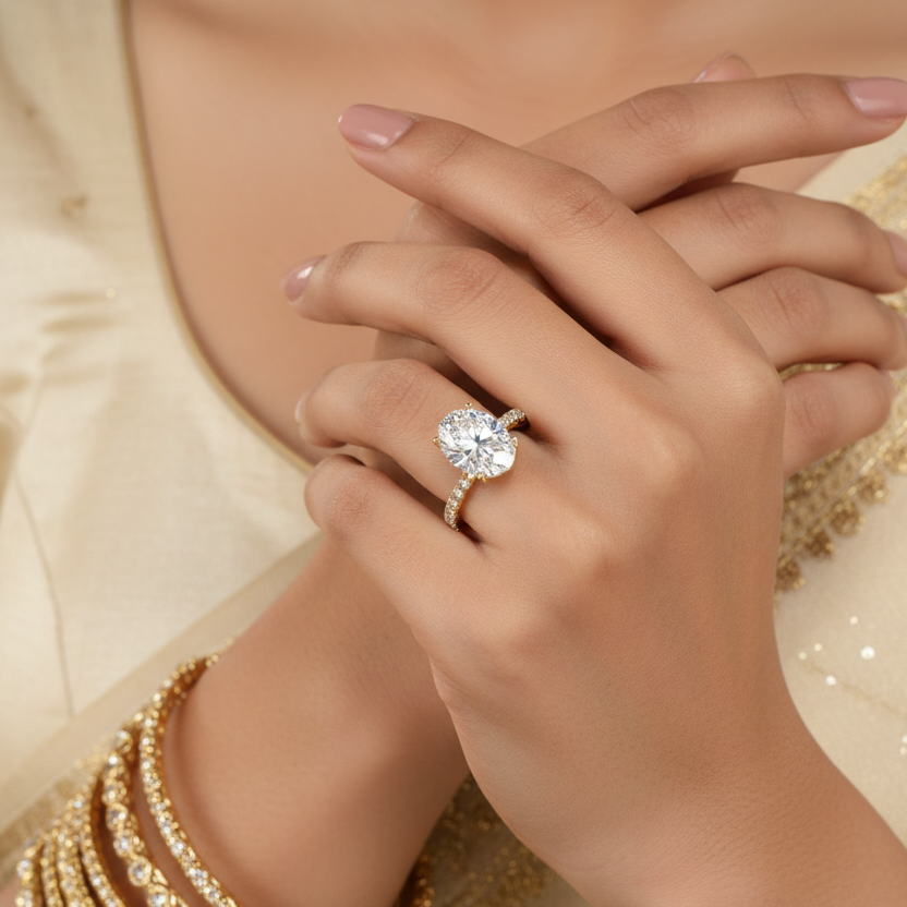 Close-up of a hand wearing a diamond ring with a gold outfit in the background