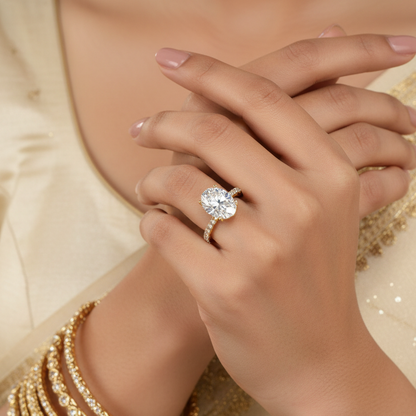 Close-up of a hand wearing a diamond ring with a gold outfit in the background