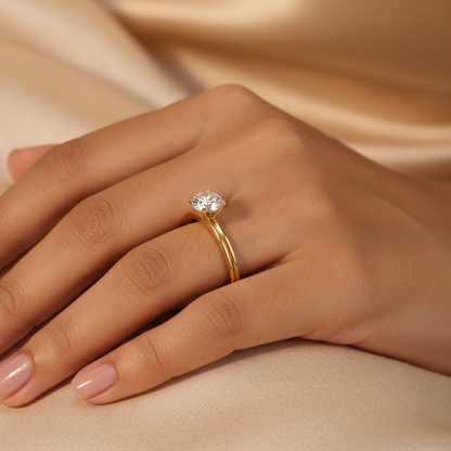Generated image of a beautiful Indian female model wearing the yellow gold round brilliant diamond four-claw solitaire engagement ring with large round brilliant diamond blazing with extraordinary icy fire in four-claw yellow gold setting on a smooth double-rail yellow gold shank with beautiful architectural channel groove running along the top