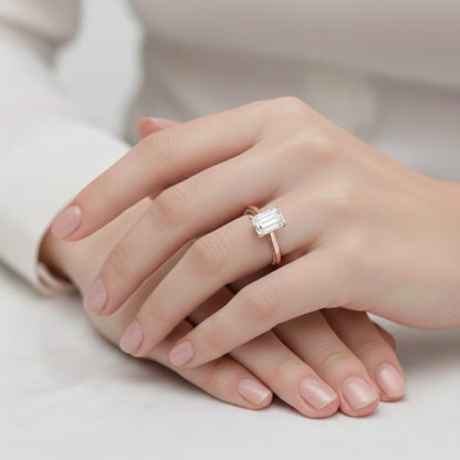 Hand wearing a rose gold diamond ring on a neutral background