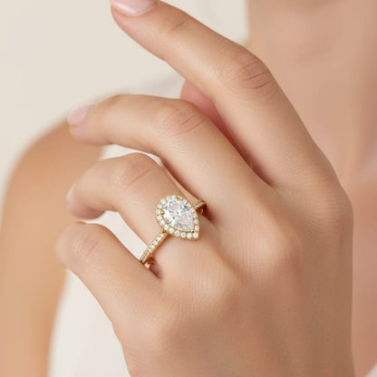 Hand wearing a gold ring with a diamond on a neutral background