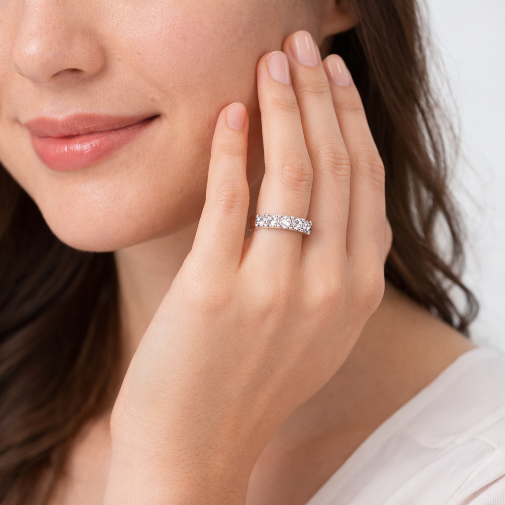 Close-up of a woman's hand wearing a diamond ring with a neutral background