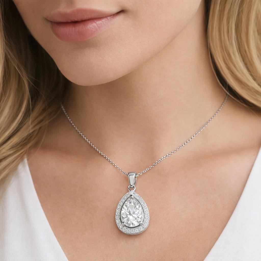 Teardrop-shaped diamond pendant on a necklace worn by a model.