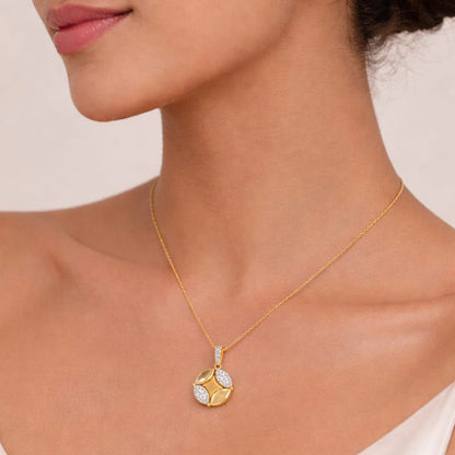 Gold necklace with a diamond pendant worn by a person in a white top.