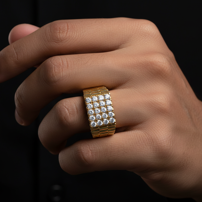 Generated image of a handsome Indian male model wearing the bold yellow gold Rolex-style diamond pavé signet ring with spectacular 4x4 grid of sixteen large round brilliant diamonds blazing with extraordinary icy fire across the entire rectangular signet face and beautiful ribbed Rolex-inspired bracelet-link texture on the sides, dramatic cinematic side light against near-black background with powerful confident masculine pose