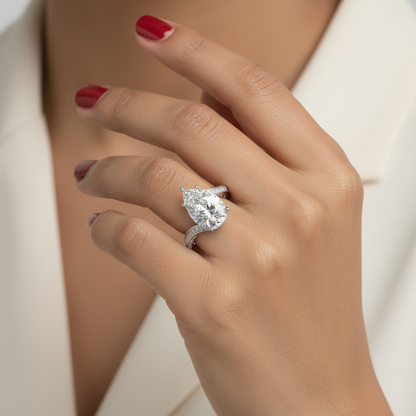 Generated image of an Indian female model wearing the white gold five-claw pear-cut diamond solitaire with spectacular split-shank pavé diamond rails sweeping elegantly apart in a dramatic sculptural embrace