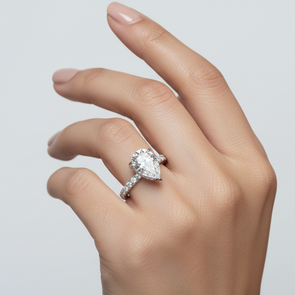 Generated image of an Indian female model wearing the white gold five-prong pear-cut diamond solitaire engagement ring with hidden micro-pavé halo under-gallery and pavé diamond band