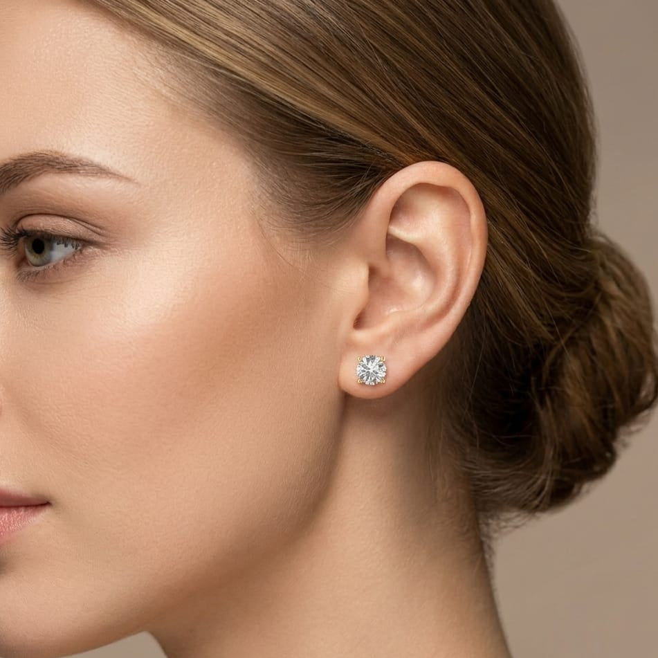 Close-up of a woman wearing a diamond earring on a neutral background