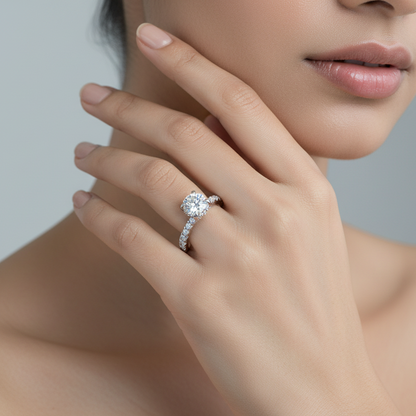 Generated image of an Indian female model wearing the white gold four-prong round brilliant solitaire engagement ring with hidden micro-pavé halo under-gallery and full pavé diamond band