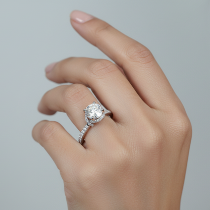 Generated image of an Indian female model wearing the white gold four-prong round brilliant solitaire engagement ring with hidden micro-pavé halo under-gallery and pavé diamond band