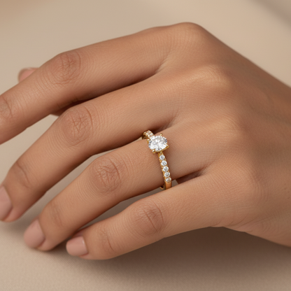 Generated image of an Indian female model wearing the yellow gold oval-cut solitaire engagement ring with U-cut pavé diamond band