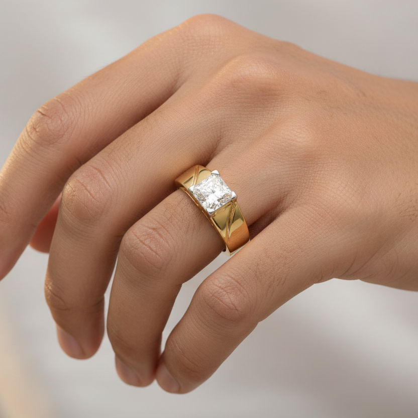 Generated image of an Indian male model wearing the 14K yellow gold four-prong princess-cut diamond solitaire men's ring with bold wide tapered band and diagonal groove shoulder detailing
