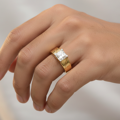 Generated image of an Indian male model wearing the 14K yellow gold four-prong princess-cut diamond solitaire men's ring with bold wide tapered band and diagonal groove shoulder detailing