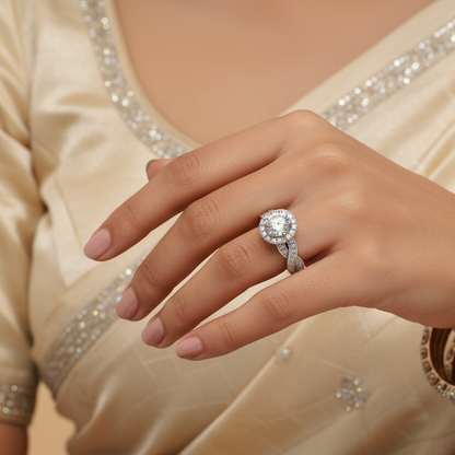 Generated Indian bridal editorial variation - beautiful Indian female model wearing the white gold round brilliant diamond halo ring with spectacular twisted infinity braided double-row pavé diamond shank, warm studio lighting on champagne background with soft ivory silk saree blouse with delicate silver embroidery, soft rose nails and delicate diamond bangles stacked alongside for a beautiful traditional Indian bridal context, all diamonds blazing simultaneously with extraordinary icy white brilliance