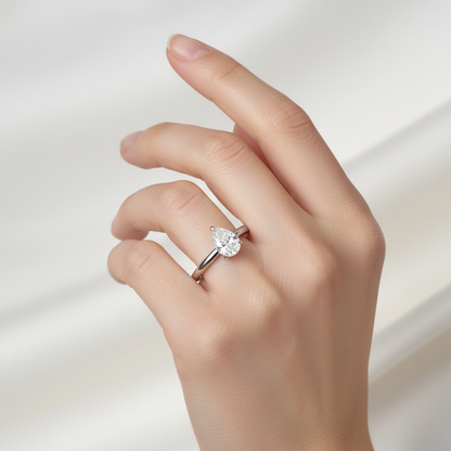 White gold pear-shaped diamond solitaire engagement ring on model