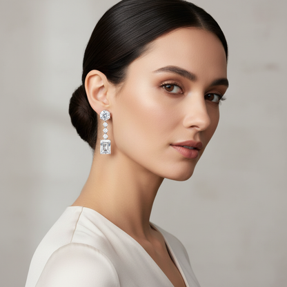 White gold round and emerald-cut diamond drop earrings on model