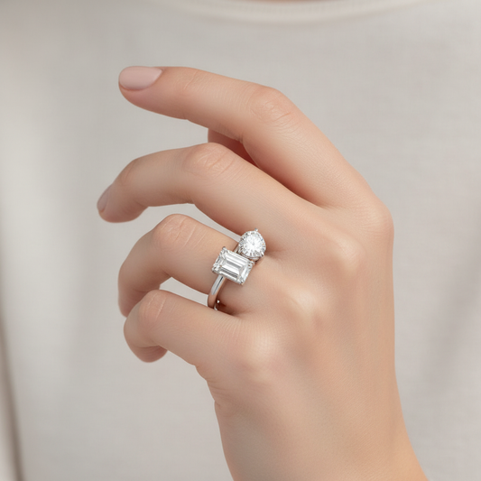 White gold two-stone toi et moi ring with emerald-cut and round brilliant diamonds on model