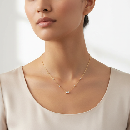 Yellow gold diamond station necklace with emerald-cut pendant on model