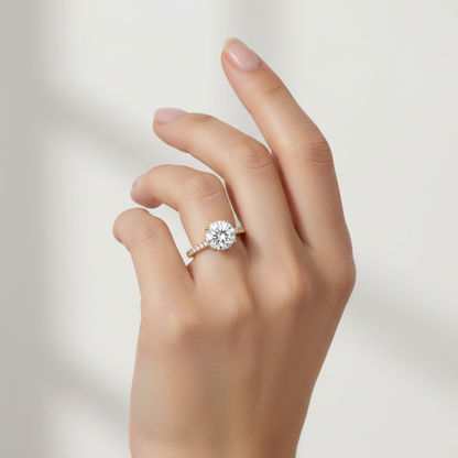 Yellow gold round brilliant diamond solitaire engagement ring with hidden halo and pavé band on model