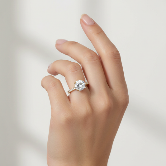 Yellow gold round brilliant diamond solitaire engagement ring with hidden halo and pavé band on model