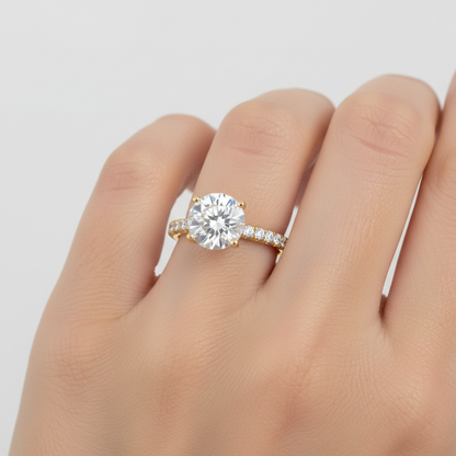 Yellow gold round brilliant diamond solitaire engagement ring with pavé band on model